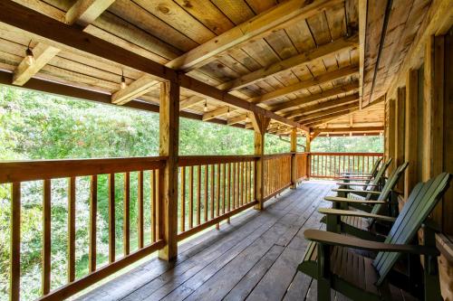 a wooden porch with rocking chairs on it at Forest Home Hot Tub Fire Pit Pool Table in Pigeon Forge