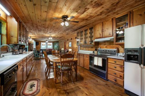 a kitchen with wooden cabinets and a table with chairs at Forest Home Hot Tub Fire Pit Pool Table in Pigeon Forge