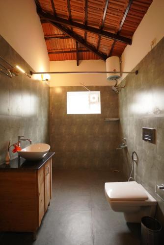 a bathroom with a sink and a toilet and a sink at Ravishing Retreat Resort in Rāmanagaram