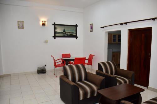 a living room with two chairs and a table at Sholay Villa in Galle