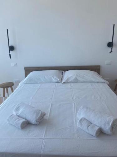 a large white bed with two towels on it at Matteotti28 in Pesaro