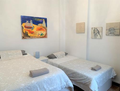 Habitación con 2 camas y una pintura en la pared. en Wide and traditional- 2Bd 1Bth- Gavidia, en Sevilla