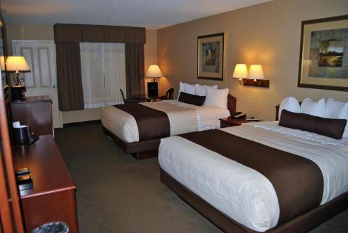 a hotel room with two beds and a desk at C'Mon Inn in Thief River Falls
