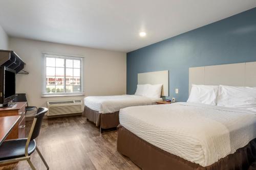 ein Hotelzimmer mit 2 Betten und einem Schreibtisch in der Unterkunft Extended Stay America Select Suites - Indianapolis - Lawrence in Fishers