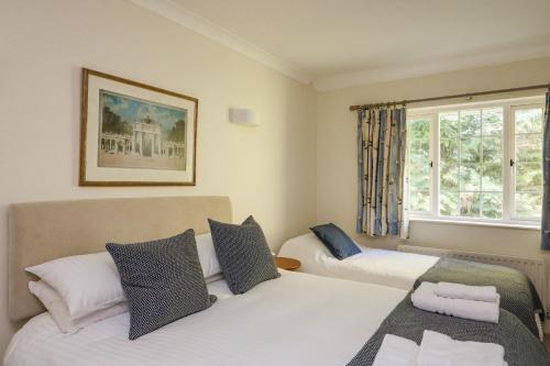 a bedroom with two beds and a window at 4 St Elmo Court in Salcombe