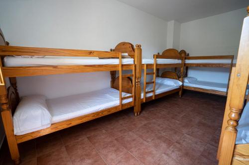 a room with three bunk beds in a room at Albergue del serpis in Lorcha