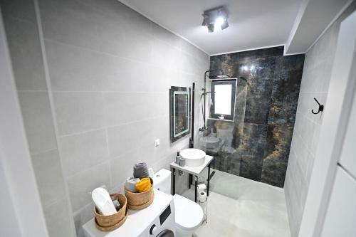 a white bathroom with a sink and a toilet at FLH - Just 5 in Şelimbăr