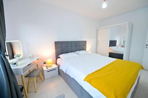 a bedroom with a large white bed and a desk at FLH - Just 5 in Şelimbăr