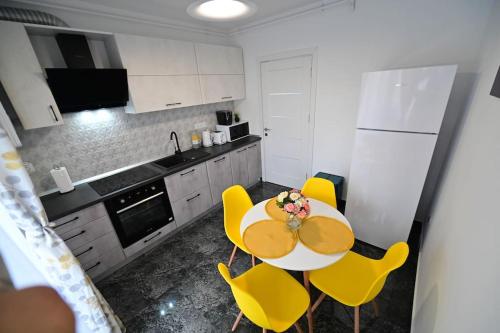 eine Küche mit einem Tisch und gelben Stühlen in der Unterkunft FLH - Just 5 in Şelimbăr