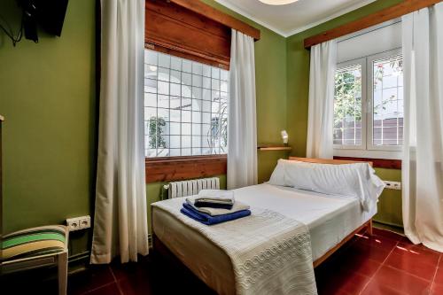 a small bedroom with a bed and a window at Casa en Sitges in Sitges