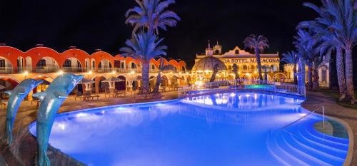 a large swimming pool in front of a building at night at Macacona Hacienda Hotel in Ica