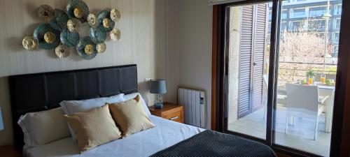 a bedroom with a bed and a sliding glass door at Acogedor apartamento con terraza en Portonovo in Portonovo
