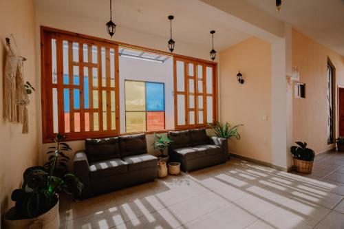 a living room with two leather couches and windows at Hotel Cielo y Selva, San Cristobal de las Casas in San Cristóbal de Las Casas