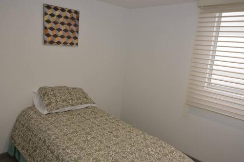 un dormitorio con una cama y una ventana en Hermoso apartamento en Paipa con vista al lago Sochagota., en Paipa