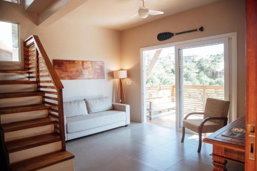 un soggiorno con un divano e una scala di Casa de Praia no Rosa - Vista Espetacular a Praia do Rosa