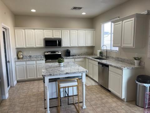 a large kitchen with white cabinets and a counter top at Luxury in Laveen in Phoenix