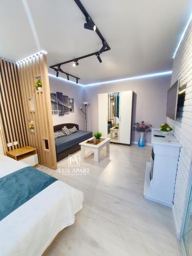 a bedroom with a bed and a living room at Lux апартаменты в центре Караганды на 45 квартале in Karagandy