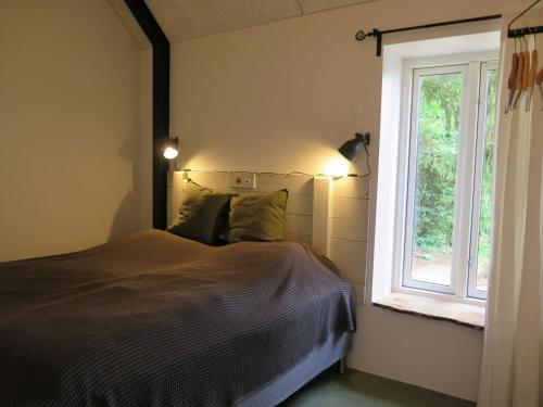 sypialnia z łóżkiem obok okna w obiekcie Ferieidyl w mieście Kettinge