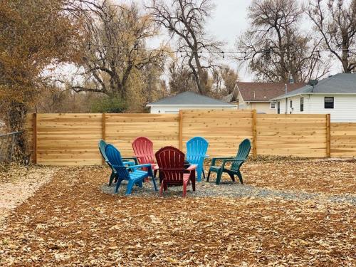 a group of colorful chairs in front of a fence at Inviting Bungalow Next to UNC - Free Cruiser Bikes in Greeley
