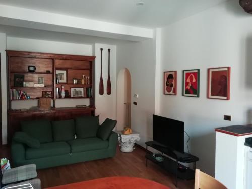 a living room with a green couch and a television at La casa di Sacco - Appartamento Bologna Centro in Bologna