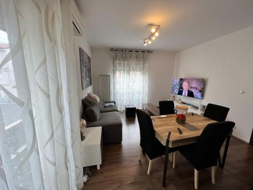 sala de estar con mesa y sofá en Grande appartamento in Centro, 4 posti letto, en Gorizia