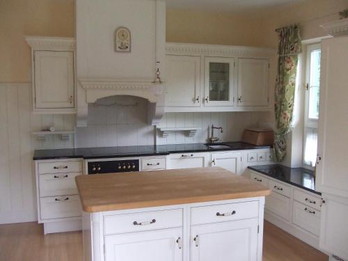 a kitchen with white cabinets and a kitchen island at Villa Rauter Mayrhofen in Mayrhofen