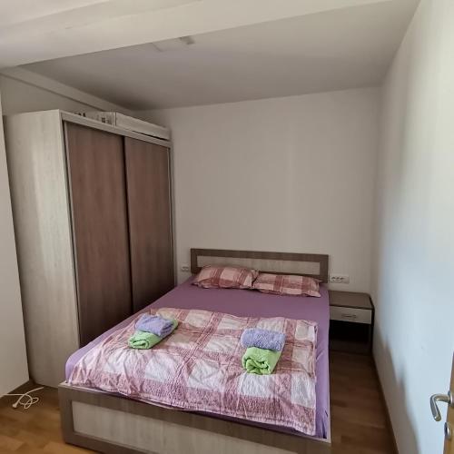 a bedroom with a bed with two pillows on it at Apartman Lea & parking u garaži in Soko Banja