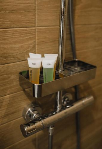 two glasses of beer on a shelf in a bathroom at Rozenstein design residence in Brocēni