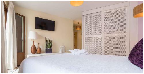 a bedroom with a white bed and a large window at Residencial Terra de Mar Calpe, Grupo Terra de Mar, alojamientos con encanto in Calpe