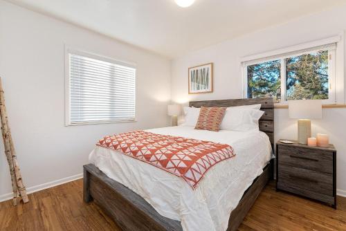 a bedroom with a large bed and two windows at Hidden Gem Near Old Town - Grill & Cruiser Bikes! in Fort Collins