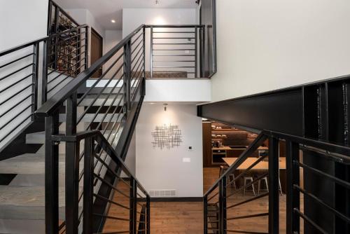 a staircase in a house with black railings at Relaxing in Paradise with Private Rooftop Deck! in Fort Collins