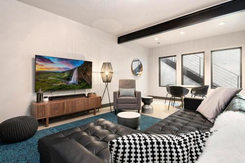 a living room with a couch and a flat screen tv at Relaxing in Paradise with Private Rooftop Deck! in Fort Collins