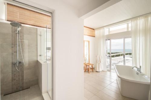 ein Bad mit einer Badewanne, einem Waschbecken und einer Dusche in der Unterkunft Villa Cambier by muse villas in Le Morne