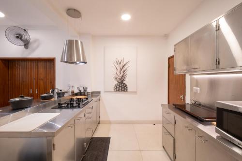 a large kitchen with stainless steel appliances and stainless steel counters at Villa Cambier by muse villas in Le Morne