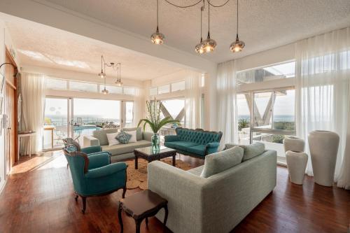 a living room with couches and chairs and a large window at Villa Cambier by muse villas in Le Morne