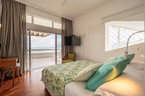 a bedroom with a bed and a desk and a window at Villa Cambier by muse villas in Le Morne