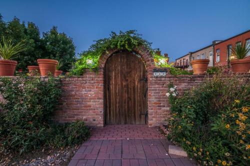 a wooden door in a brick wall with plants at Elegant Loft-Style Retreat in Old Firehouse Alley in Fort Collins