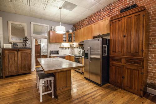 kuchnia z ceglaną ścianą i lodówką ze stali nierdzewnej w obiekcie Elegant Loft-Style Retreat in Old Firehouse Alley w mieście Fort Collins