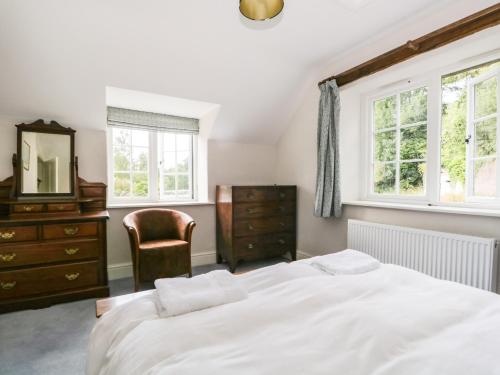a bedroom with a bed and a mirror and a chair at Caldhu Cottage in Holmrook