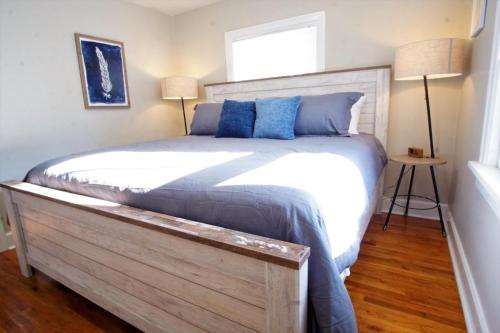 een slaapkamer met een groot bed met blauwe kussens bij Beautiful Bungalow Next to UNC - Free Cruiser Bikes! in Greeley