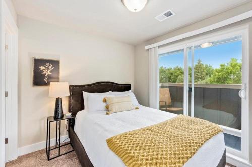a bedroom with a bed and a large window at Contemporary Studio - Sunny, Stylish and Spacious in Fort Collins