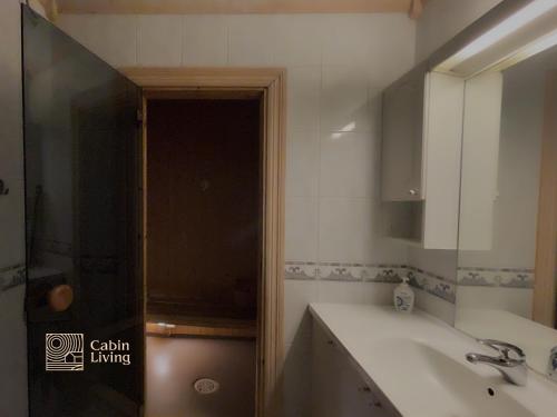 a bathroom with a sink and a mirror and a shower at Nice apartment in Trysil ski in-out, sauna and view in Trysil