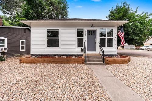a white house with a flag in front of it at Cozy Chic Home In Downtown Loveland! in Loveland