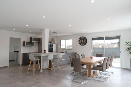 une cuisine et une salle à manger avec une table et des chaises dans l'établissement La bollevilla, à Saint-Nicolas-de-Pierrepont