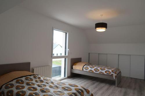 1 dormitorio con 2 camas y ventana en La bollevilla, en Saint-Nicolas-de-Pierrepont