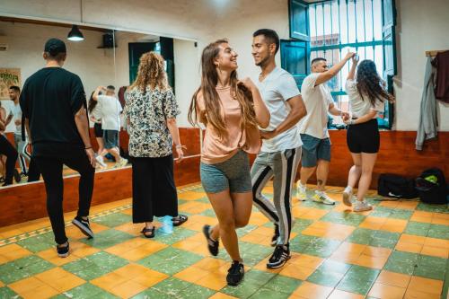 Eine Gruppe von Menschen, die in einem Tanzkurs tanzen in der Unterkunft Viajero Hostel Cali & Salsa School in Cali
