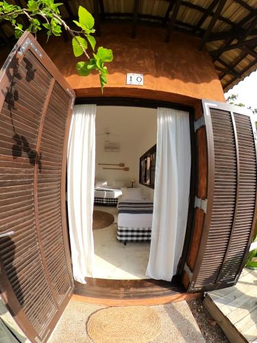 an open door to a room with a bed at Pousada Armação dos Ventos in Ilhabela