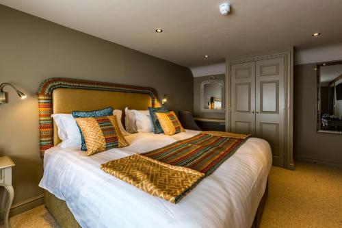a bedroom with a large bed with pillows at Washingborough Hall Hotel in Lincoln