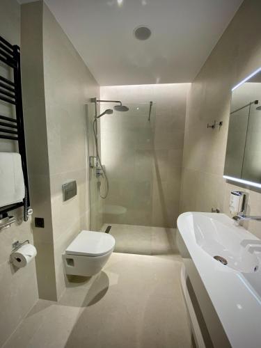 a bathroom with a shower and a toilet and a sink at Verano Centrum Zdrowia i Relaksu in Kołobrzeg