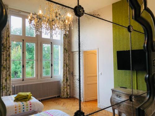 a bedroom with a chandelier and a bed in a room at Château Fauchey in Cardan